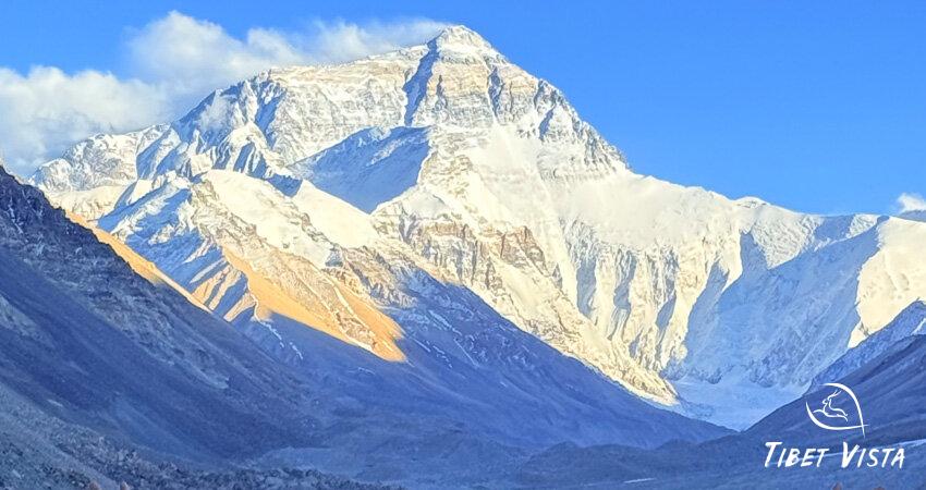 the sun set over the towering north face of Mount Everest